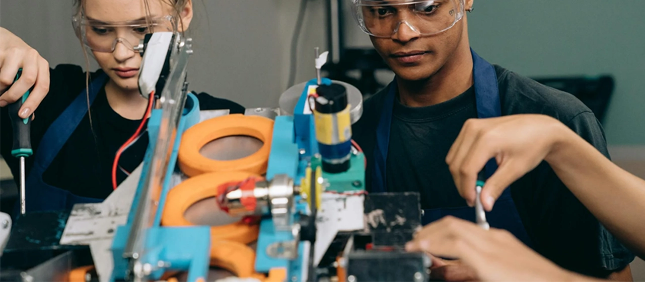 two teenagers manufacturing a machine
