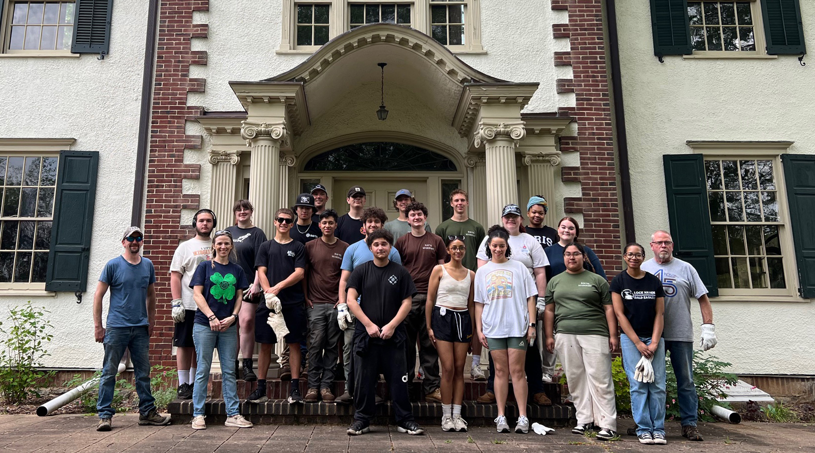 Students and teachers in front of the Archie Mansion posing after cleaning up the site