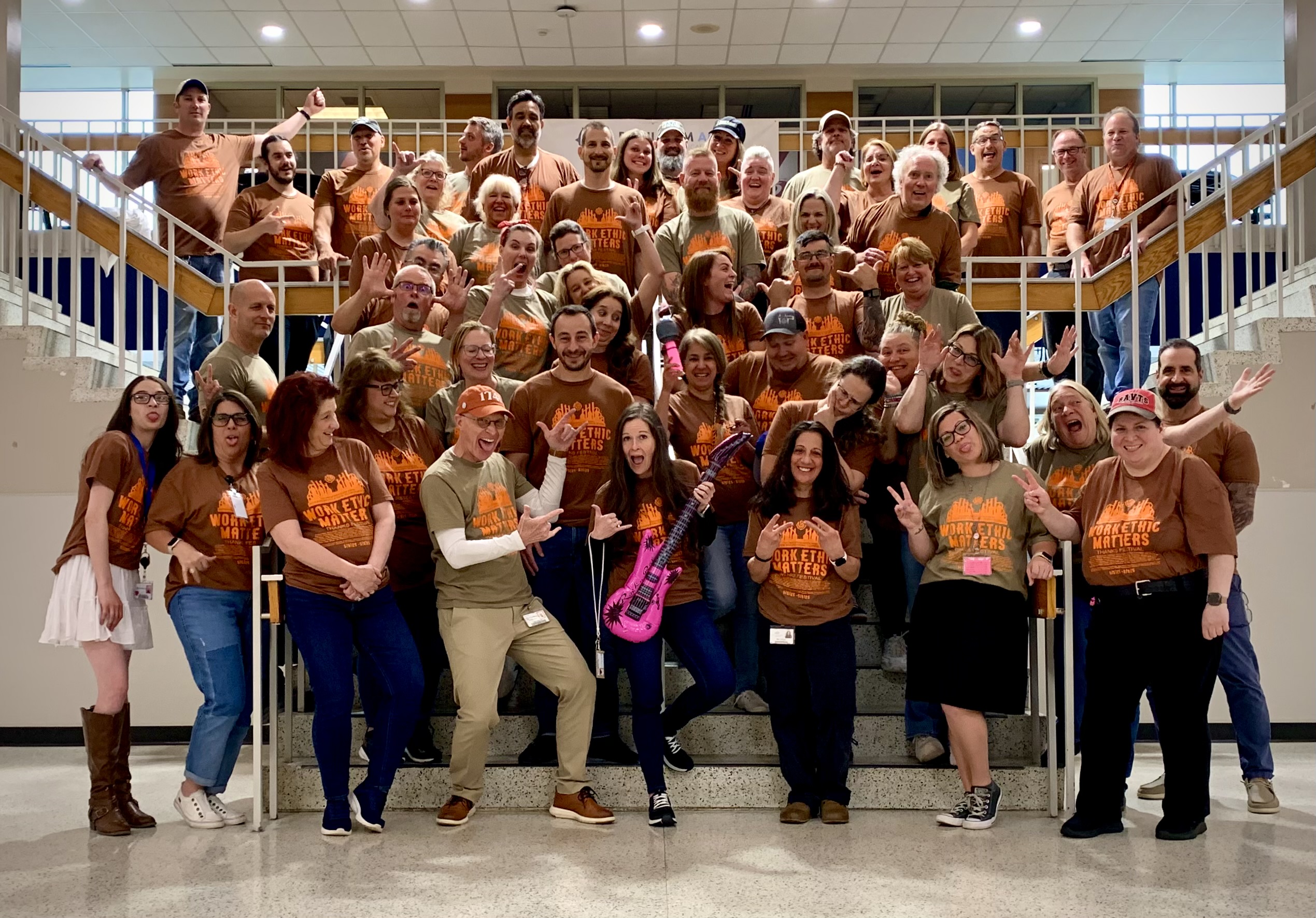 BAVTS Staff Rock out to Work Ethic Matters in Concert 1, BAVTS staff pictured in the lobby with marching work ethic matters concert style t-shirts being goofy